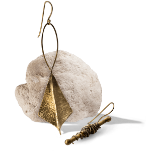 گوشواره بادبادک دست اسز برنجی بر روی سنگ معدنی سفید